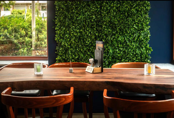 Sfeervolle houten tafel met groene wand in hip restaurant Utrecht