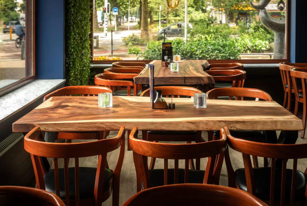 Houten tafels bij het raam in sfeervol restaurant Utrecht